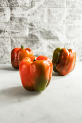 Colorful vegetables, yellow, green and red bell peppers on gray wall background