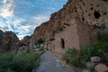 This ancestral Pueblo stone  structure at the bottom of a cliff was reconstructed during the 1920, wooden vigas support the roof,  Talus House, Bandelier NM