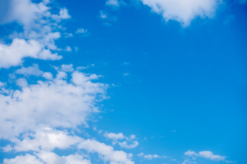 Natural sunny blue sky background with beautiful puffy white cumulus clouds