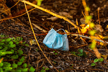A mouth and nose mask lies soiled in a German forest
