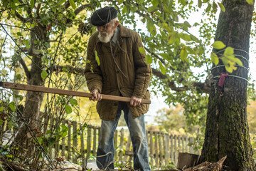 An old man works in the garden. Long-live in Russia. A man over ninety years old.