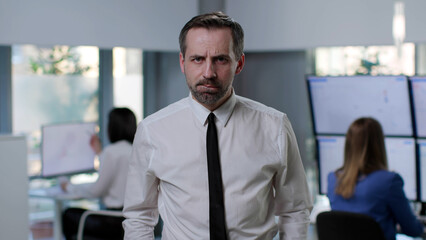 Naklejka premium Portrait of pensive sad entrepreneur looking at camera standing in modern office