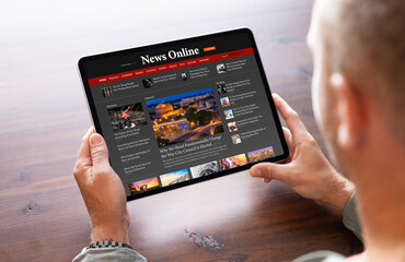 Man reading news on tablet computer