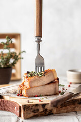 Grilled pork steak sliced with fork on serving board with herbs and spices in rustic style