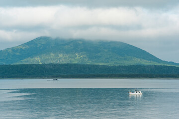 sea bay with foggy mountains in the background, view of the Mendeleev volcano on a cloudy day