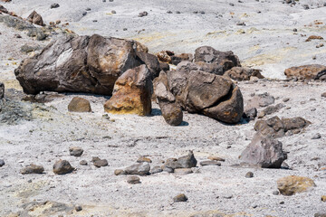 volcanic bombs among the tephra in a fumarole field on the slope of a volcano