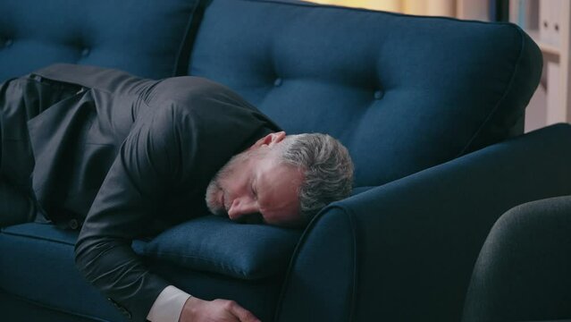 Exhausted middle-aged businessman lying on sofa, problems at work, burnout