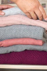 Pile of gray and pink wool sweaters in a room