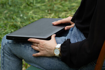 female hands open a laptop, on the street, in the fresh air, the beginning of the working day, free schedule,