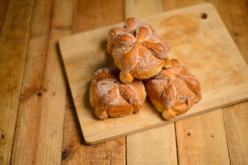 Pan de muertos on a wooden table. Typical Mexican dessert for the Day of the Dead. Top view.