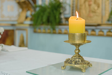 chandelier with lit candle on the altar of the catholic church