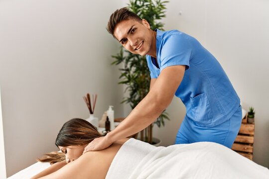 Physiotherapist making massage to woman at beauty center.