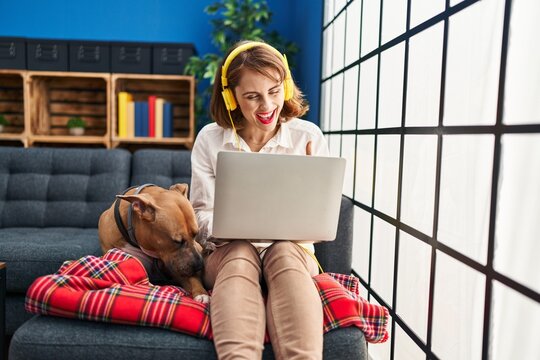 Young beautiful woman using laptop sitting on the sofa pointing finger to one self smiling happy and proud