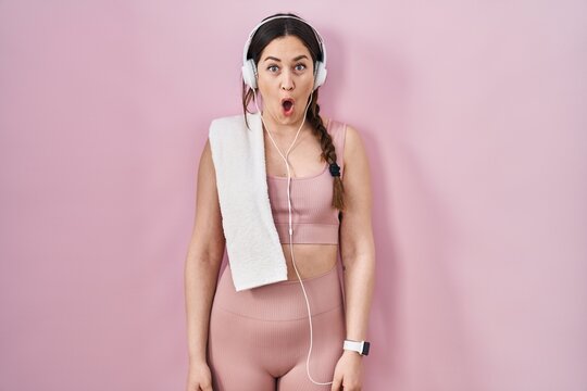Young brunette woman wearing sportswear and headphones afraid and shocked with surprise expression, fear and excited face.