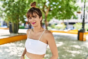 Young hispanic woman smiling happy standing at the city.