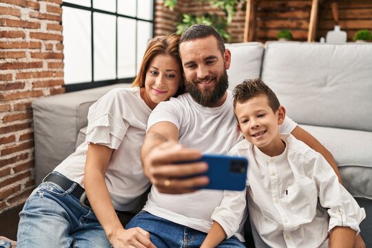 Family make selfie by smartphone sitting on floor at home