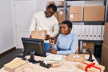 Man and woman ecommerce business workers scanning package at office