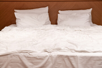 White pillows, blankets and sheets on a large bed