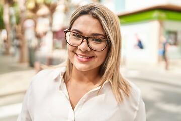 Young hispanic woman smiling confident standing at street