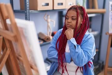 African american woman artist looking draw with doubt expression at art studio