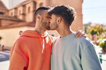 Two man couple hugging each other and kissing at street