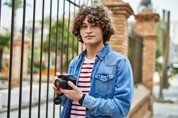 Young hispanic man using photography camera at the city