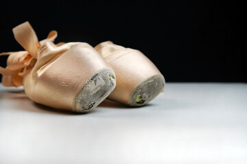 old ballet pointe shoes on a white background close-up