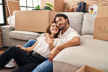 Fototapeta premium Man and woman couple smiling confident hugging each other at new home