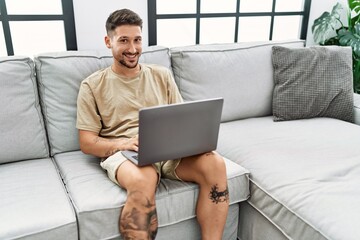 Young hispanic man smiling confident using laptop at home