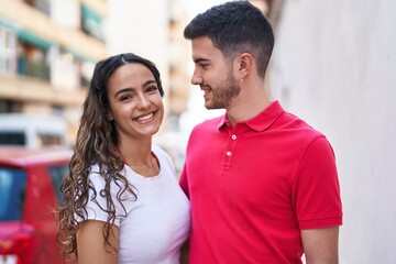 Fototapeta premium Young hispanic couple smiling confident hugging each other at street