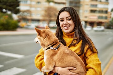 Beautiful young woman hugging happy shiba inu dog at street