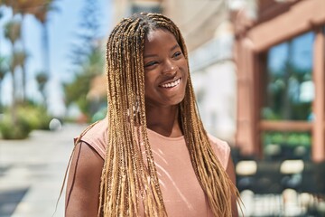 African american woman smiling confident looking to the side at coffee shop terrace