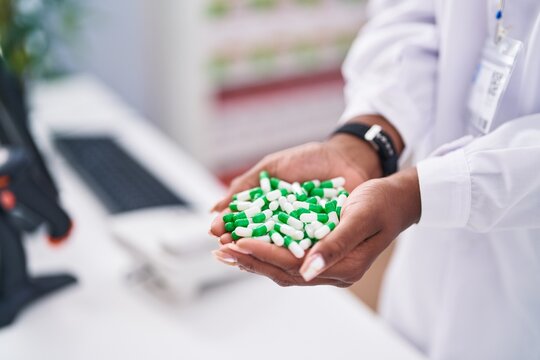African american woman pharmacist holding pills at pharmacy
