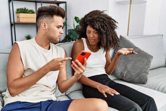 Man and woman couple with problems using smartphone at home