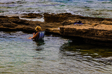 a woman sits on a chair in the sea