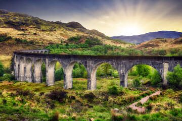 Scotland landscape - Glenfinnan train Viaduct at dramatic sunset with sun, UK