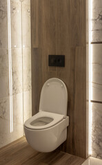 Part of the bathroom with a view of the open toilet and wood-like tiles on the wall. - 528107996