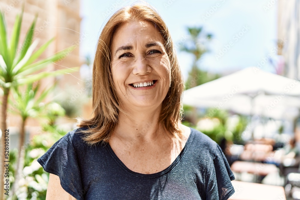 Wall mural Middle age hispanic woman smiling happy outdoors on a sunny day