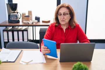 Senior woman business worker using laptop and touchpad at office