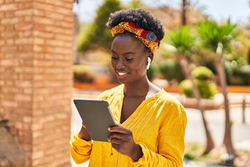 Young african american woman smiling confident using touchpad at street