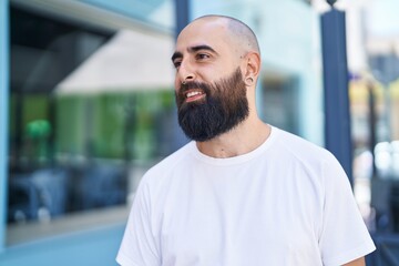 Obraz premium Young bald man smiling confident looking to the side at street