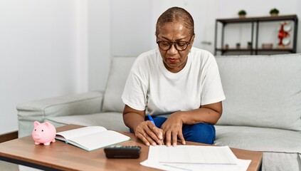 Senior african american woman controlling economy at home