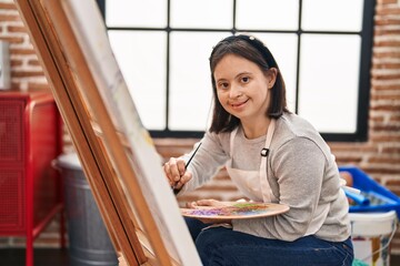 Young woman with down syndrome artist smiling confident drawing at art studio
