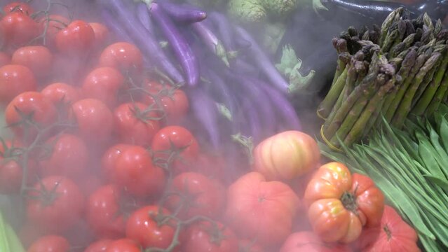 Grupo de vegetales frescos expuestos en una frutería con nebulización para frutas y verduras.