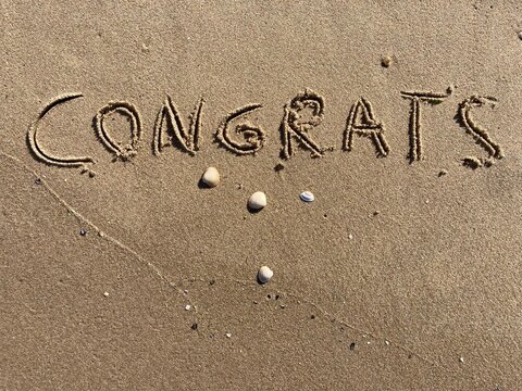 on the beach is carved with letters in the smooth sand the writing congrats