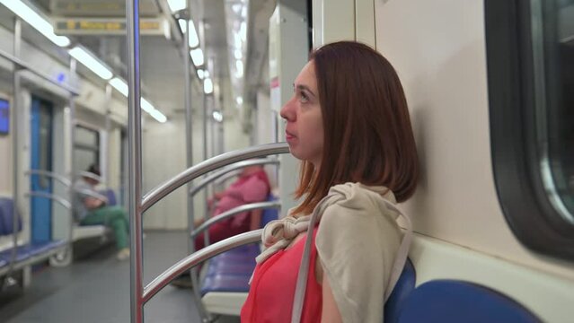 Woman sitting in metro in the evening. 4k video footage