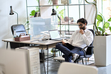 Busy young indian business man manager working sitting in office at work checking appointments organizing agenda in calendar planner planning schedule at workplace. Time management concept