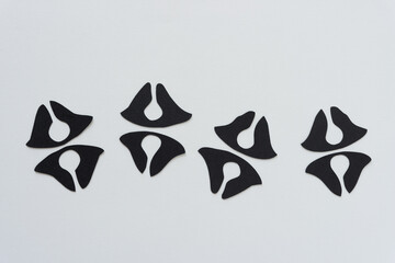 Obraz premium black paper shapes (tooth-like) on blank paper background