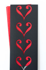 ornamental stencil with heart-like shapes on red tissue and blank paper