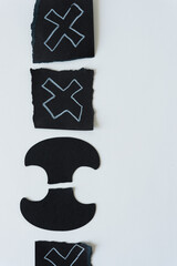 abstract paper shapes with x shapes on black paper square